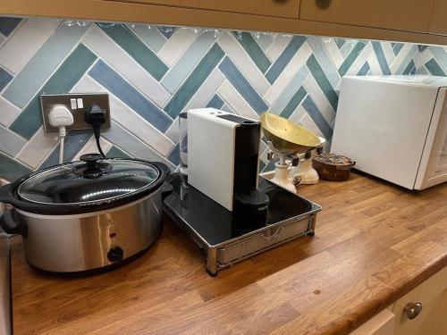 a kitchen counter with a slow cooker and a food processor at Penolva Beach Side Apartment in Perranporth