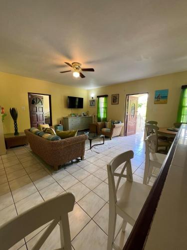 a living room with a couch and a table at Cozy & Convenient Stay Near Beach, Airport & More! in Koolbaai