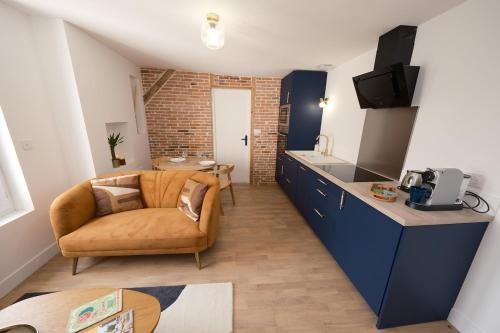 un salon avec un canapé et une cuisine dans l'établissement Appartement cosy en centre ville de Cholet, à Cholet