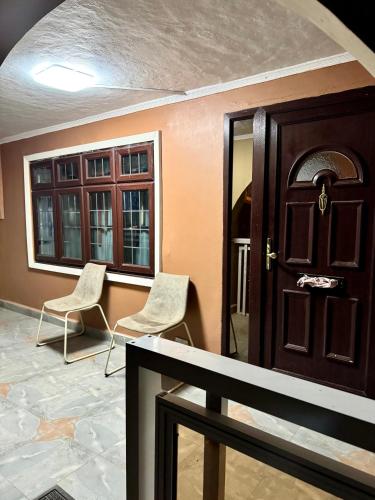 a room with two chairs and a door and windows at Yazmin Studio Residence in Lamin