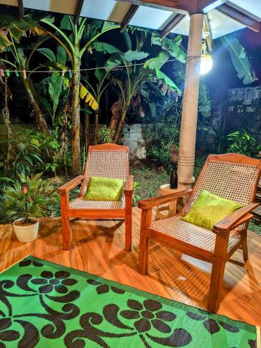 two chairs and an umbrella on a wooden floor at Green Eyes Villa in Habaraduwa Central