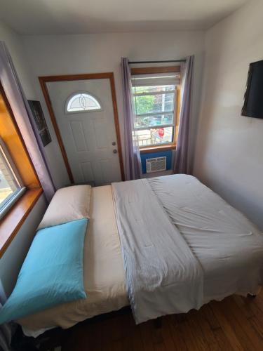 a bedroom with a large bed and a window at Nice rooms Woodside in Queens