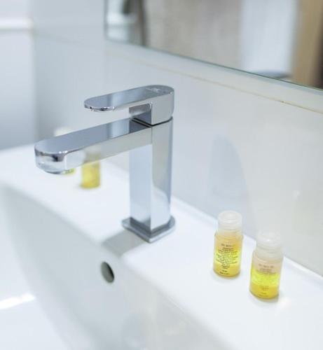 a bathroom counter with a sink with two glass jars at Casa Rural Castillo de Cáceres in Cáceres