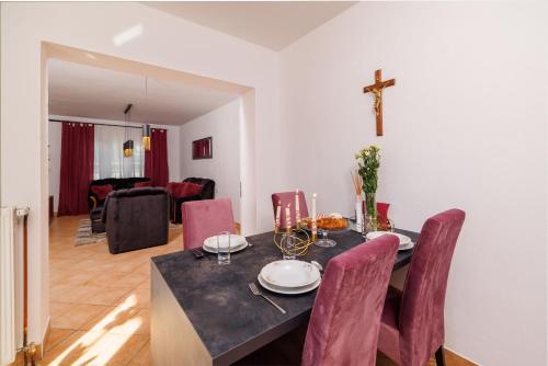 a dining room with a table and a cross on the wall at Apartments Sofija in Fužine