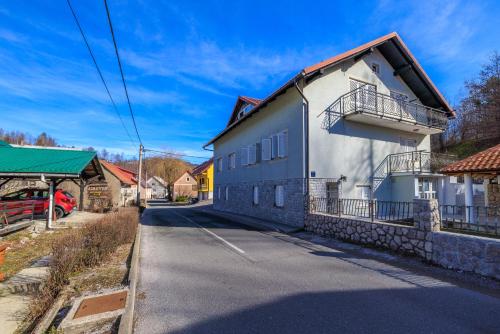 a white building on the side of a street at Apartments Sofija in Fužine
