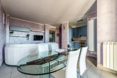 a dining room with a glass table and white chairs at Hostly-Family Home Fosso Vecchio-Relax in Tuscany in Cascina