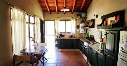 a kitchen with a table and a counter top at CACHEUTA Casa de Montaña in Ciudad Lujan de Cuyo