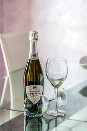 a bottle of wine and a wine glass on a table at Hostly-Family Home Fosso Vecchio-Relax in Tuscany in Cascina