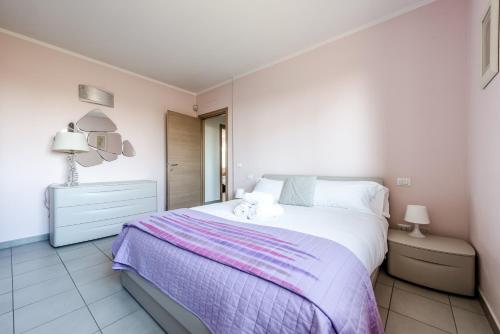 a bedroom with a large bed with a purple blanket at Hostly-Family Home Fosso Vecchio-Relax in Tuscany in Cascina