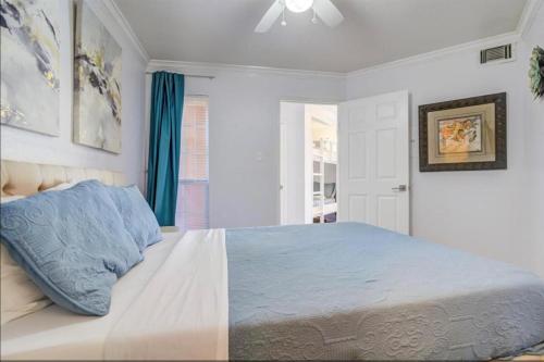 a bedroom with a bed with a blue pillow on it at Ocean & Pool Views on seawall - Shoreline Stays 10 in Galveston
