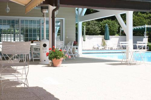 a patio with a table and chairs and a pool at Chalet La Forestière in Saint-Paul-en-Chablais