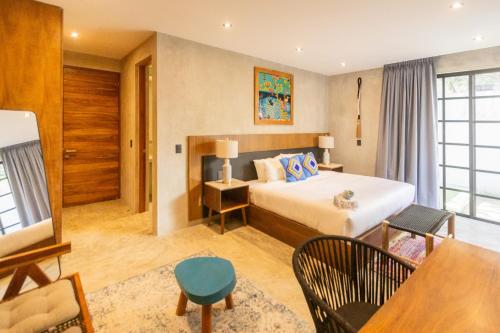 a hotel room with a bed and a table at Turquoise Tulum Hotel in Tulum