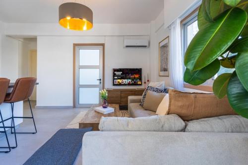 a living room with a couch and a tv at Elegant City Central Suite in Nicosia