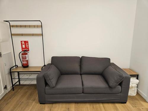 a couch sitting in a living room next to a wall at Loft moderno en Lezkairu UAT01756 in Pamplona