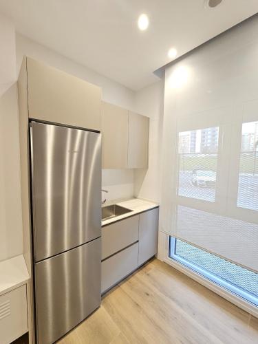 a kitchen with a stainless steel refrigerator and a window at Loft moderno en Lezkairu UAT01756 in Pamplona