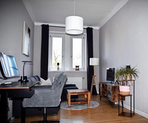 a living room with a desk and a piano at Lüner Apartment in Lüneburg