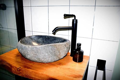 a stone sink on a wooden counter in a bathroom at Lüner Apartment in Lüneburg