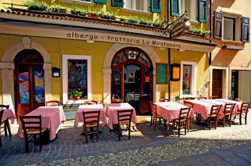 un grupo de mesas y sillas fuera de un restaurante en Albergo La Montanara, en Riva del Garda