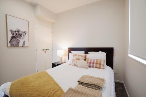 a bedroom with a large bed with a yellow blanket at 4 bedrooms Retreat with Netflix with Prime Location in Auckland