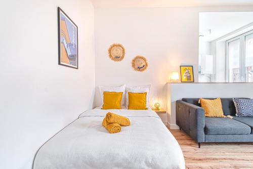 une chambre avec un grand lit et un canapé dans l'établissement Le Majorelle - Hypercentre - Quartier Apaisant, à Angers
