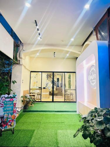 a building with a lobby with green grass at Dedbaicha cafe & Hostel Phuket old town in Phuket