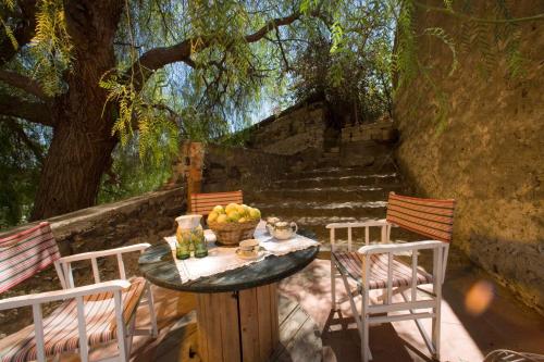 una mesa con un bol de fruta y dos sillas en Fondo Cipollate en Castiglione di Sicilia