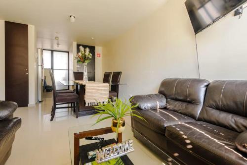 a living room with a leather couch and a table at Shinyado CDMX in Mexico City
