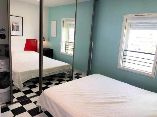 Cette chambre comprend 2 lits et un miroir. dans l'établissement Résidence Port Nature Colline 4 - 2 Pièces 2 Personnes n477 - Naturiste, au Cap d'Agde