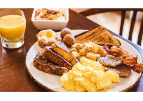 a plate of breakfast food on a table with a glass of orange juice at Williamsburg Lodge, Autograph Collection in Williamsburg