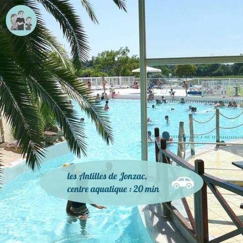 - une piscine dans un complexe avec un panneau dans l'eau dans l'établissement Maison Chelona Peinte par Chelona'Loc, à Saint-Ciers-du-Taillon