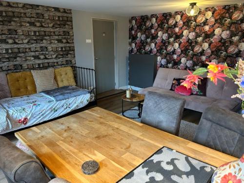a living room with a couch and a table at De Cordobahoeve in Tweede Exloërmond