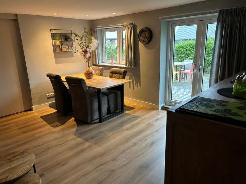 a kitchen with a table and chairs and a dining room at De Cordobahoeve in Tweede Exloërmond