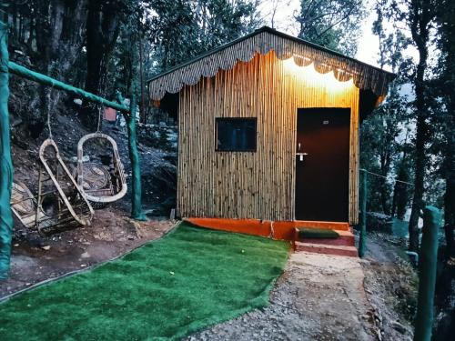 a small wooden building with a small green yard at TTN - The Trekker's Nest in Joshīmath