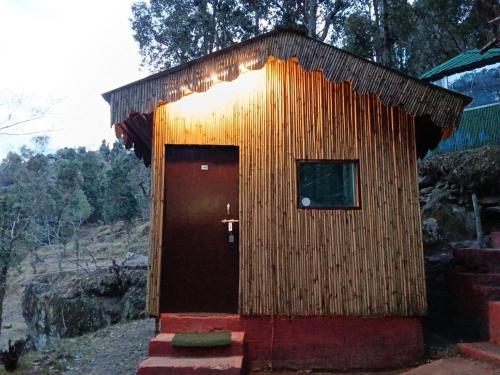 a small wooden building with a door and a window at TTN - The Trekker's Nest in Joshīmath