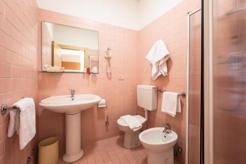 a pink bathroom with a sink and a toilet at Hotel Ca' Di Valle in Cavallino-Treporti