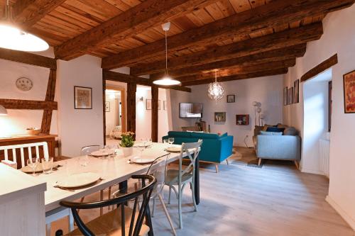 une salle à manger et un salon avec une table et des chaises dans l'établissement Grand gîte dans maison alsacienne historique, à Gueberschwihr