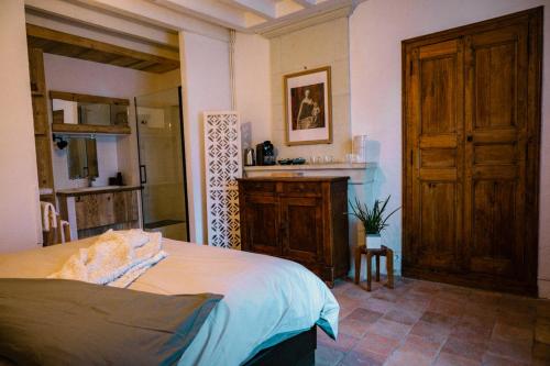 a bedroom with a large bed and a bathroom at B&B BienViennue in Marcilly-sur-Vienne