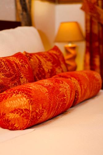 a row of pillows on a bed with a lamp at Poas Volcano Lodge in Vara Blanca