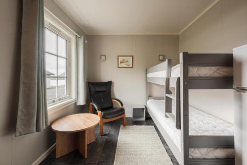 a small room with two bunk beds and a chair at Oppmyre Camping in Myre