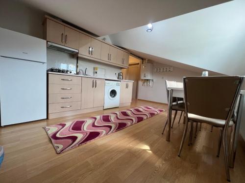 y cocina con mesa y lavadora. en Ürgüp Manzaralı Ev Teras, en Ürgüp