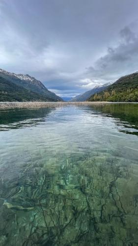 a large body of water with rocks in it at Refugio de Montaña Patagonia, pesca, trekking, miradores in Llanada Grande