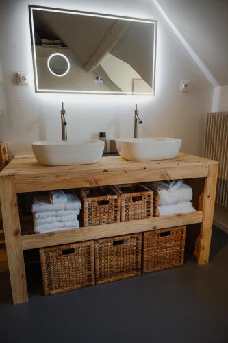 a bathroom with two sinks and wicker baskets at B&B BienViennue in Marcilly-sur-Vienne