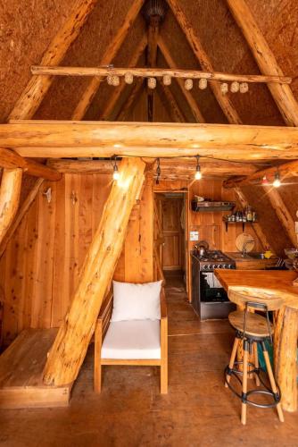 a kitchen in a log cabin with a table at Refugio de Montaña Patagonia, pesca, trekking, miradores in Llanada Grande