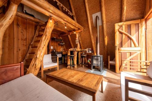 a living room with a staircase in a log cabin at Refugio de Montaña Patagonia, pesca, trekking, miradores in Llanada Grande