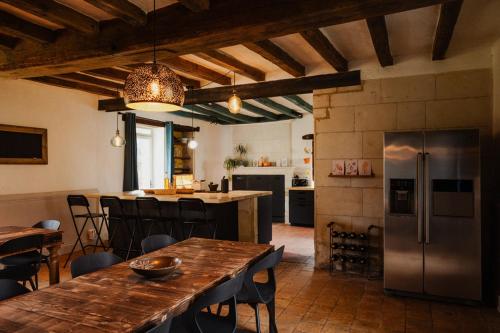 a kitchen with a wooden table and a refrigerator at B&B BienViennue in Marcilly-sur-Vienne