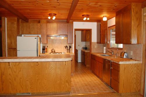 a large kitchen with wooden cabinets and a refrigerator at Mountain Retreat in Wawona