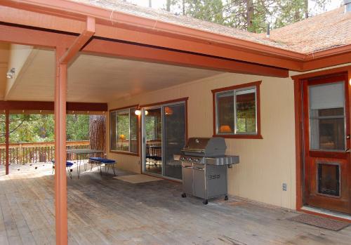 a screened in porch with a grill on a patio at Mountain Retreat in Wawona