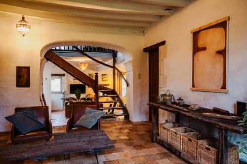 a living room with a wooden staircase and a mirror at B&B BienViennue in Marcilly-sur-Vienne