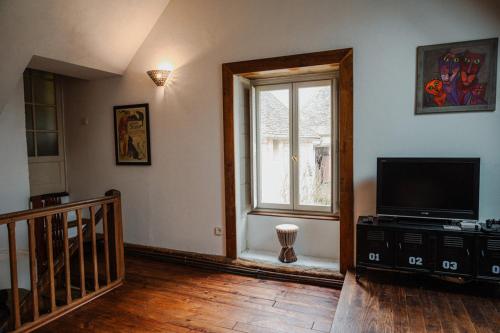 a living room with a television and a window at B&B BienViennue in Marcilly-sur-Vienne