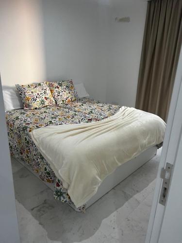 Una cama con sábanas y almohadas florales en un dormitorio en MSV Beach, en Puerto Naos